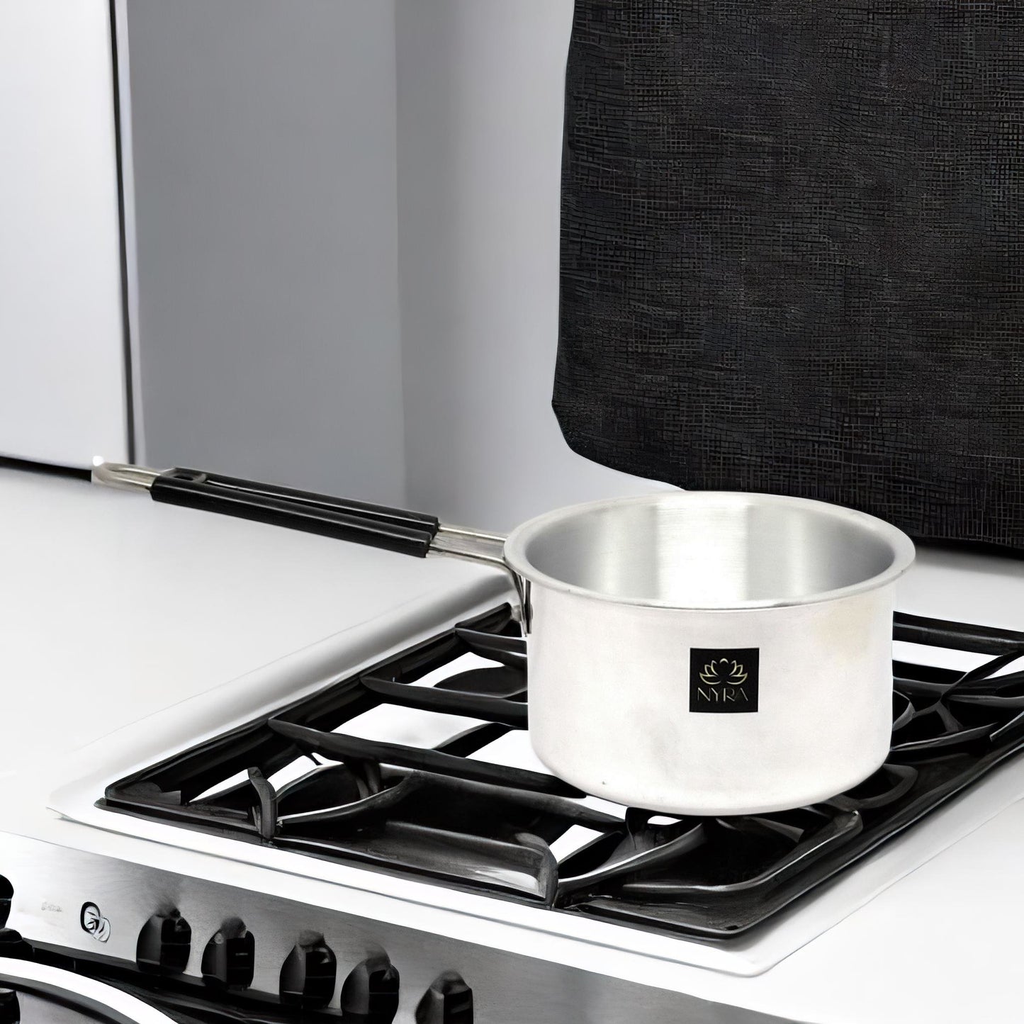 Silver pot on a gas stove with a black background
