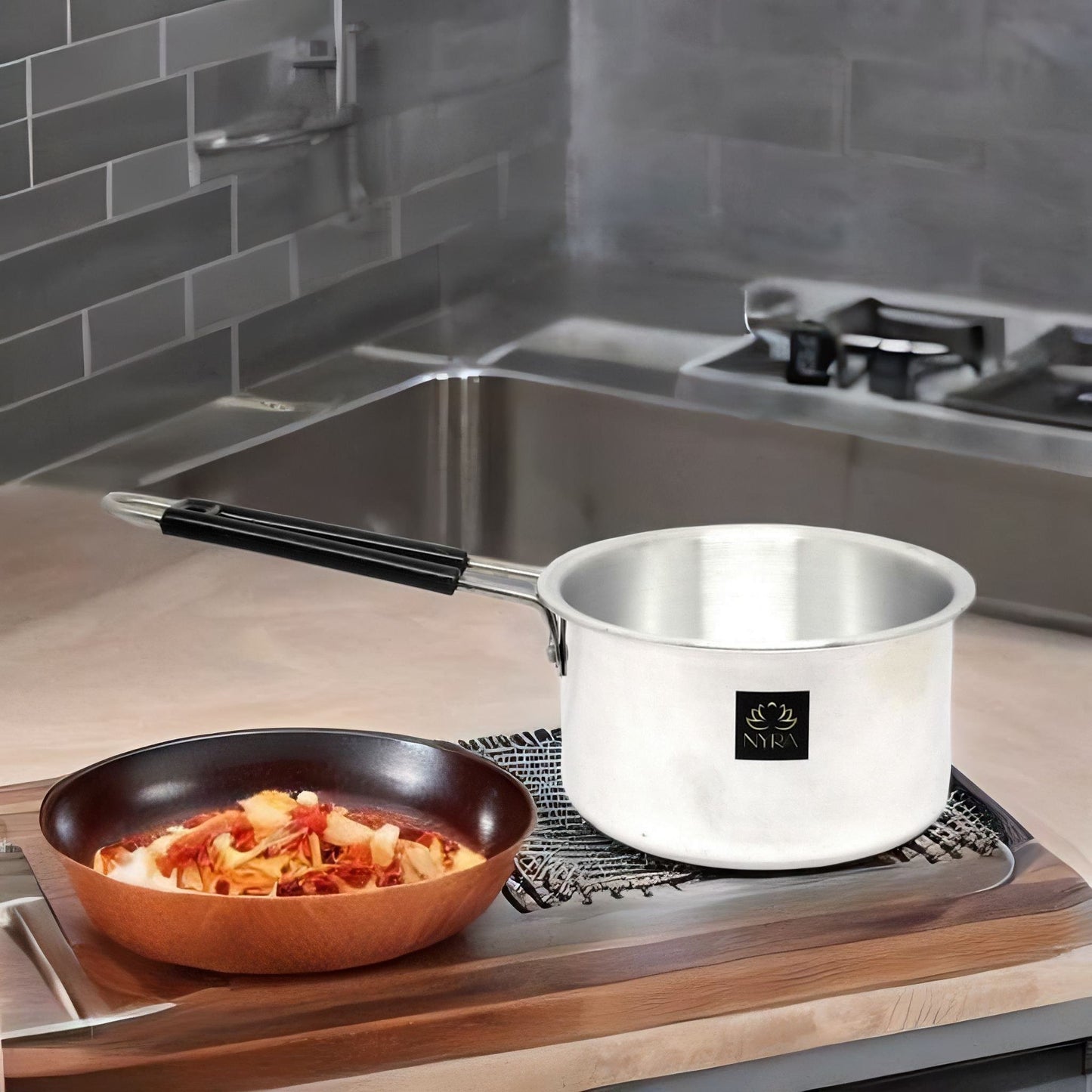 Stainless steel pot on a stove with a bowl of food nearby in a kitchen setting