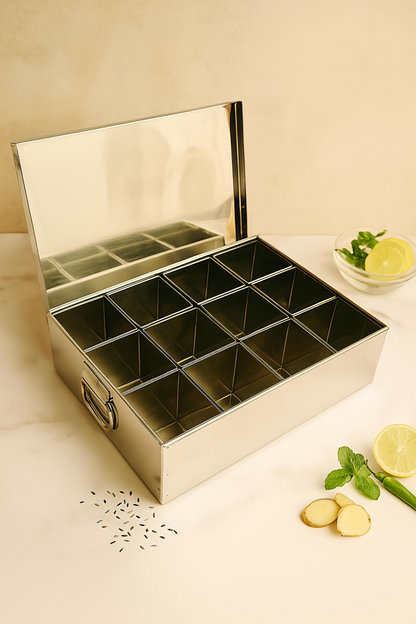 Metallic tea box with compartments on a light surface with lemons and mint.