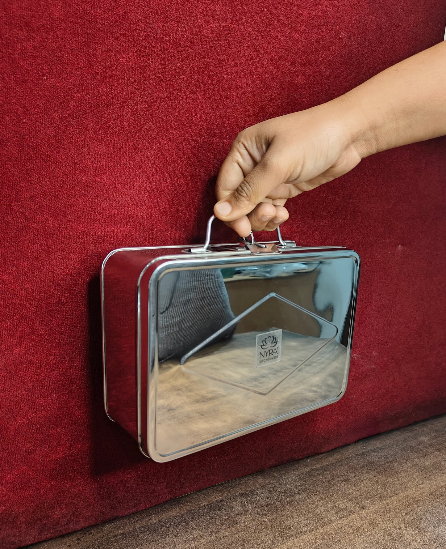 Metallic briefcase with hanger on a red surface