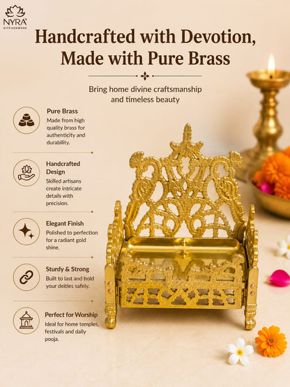 A brass throne-style lamp or decorative pedestal shown on a warm beige promotional graphic with text callouts, a lit diya, flowers, and the NYRA Attacheers logo. The product itself is metallic gold/brass and is the main sold item, while the surrounding props and text are part of the marketing layout rather than separate products.
