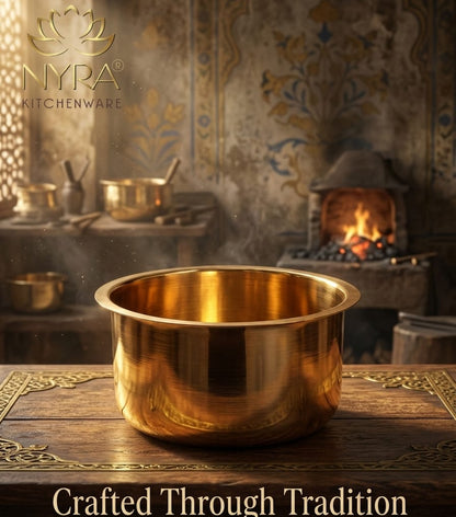 Brass pot on a wooden surface with a warm, rustic background featuring a fireplace.