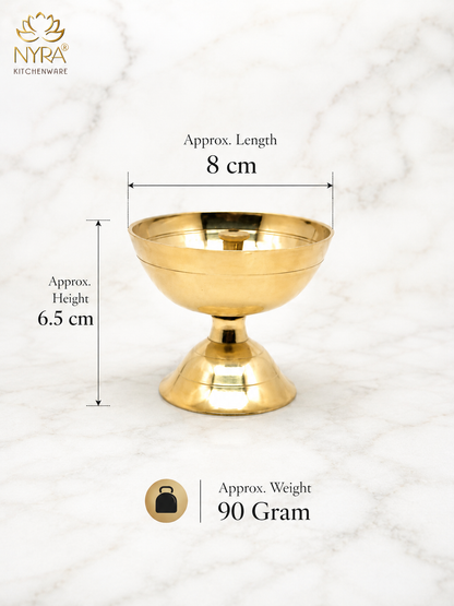 A gold-colored brass pedestal bowl shown on a white marble background with dimension lines indicating a length of 8 cm and height of 6.5 cm, along with a weight of 90 grams.