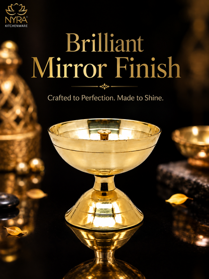 A polished gold-toned pedestal bowl or chalice with a reflective mirror-like finish, centered on a dark background with decorative props and the text 'Brilliant Mirror Finish' and 'Crafted to Perfection. Made to Shine.