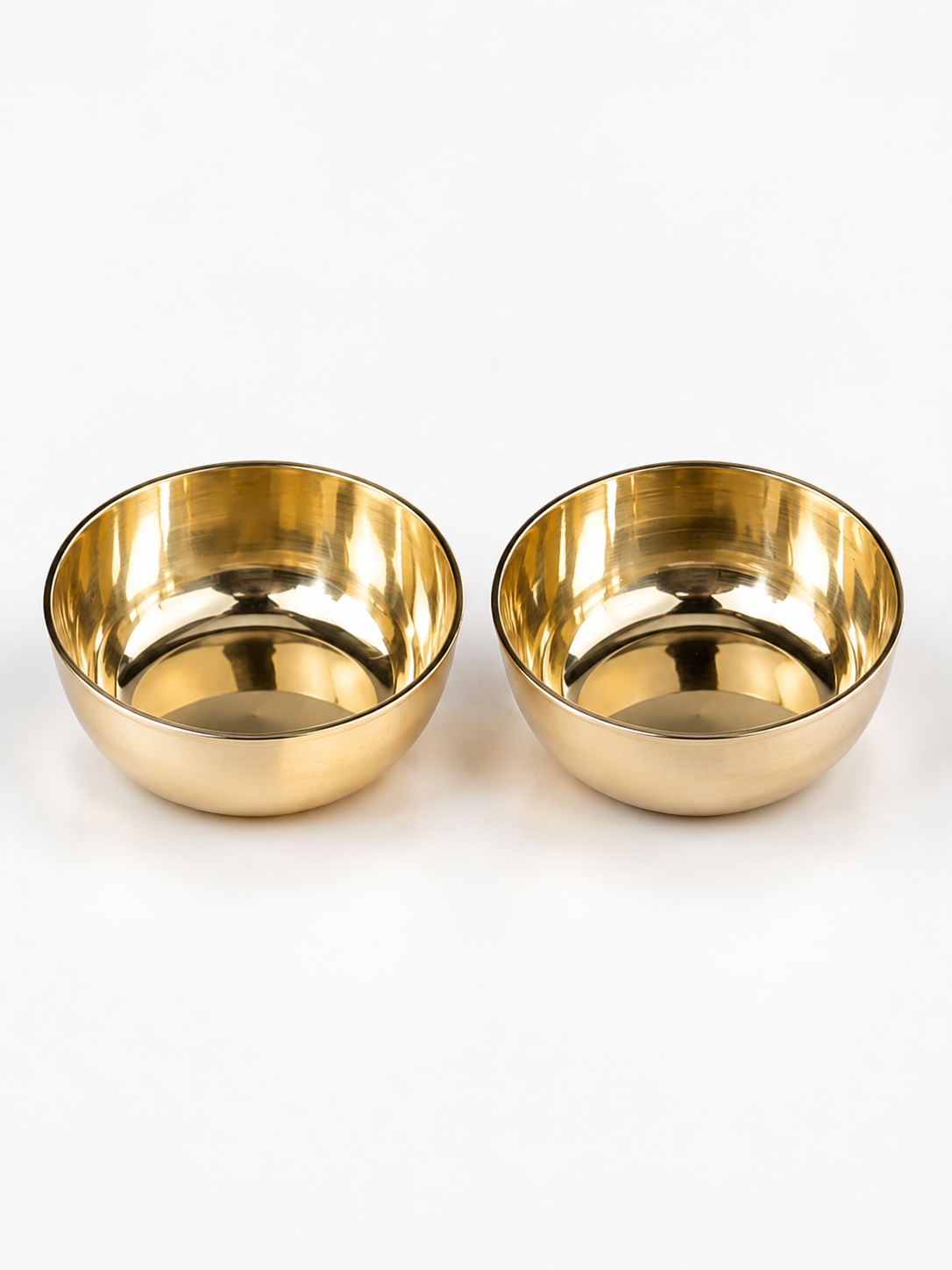 Two small round metallic bowls with a polished gold finish, shown side by side on a clean white background.