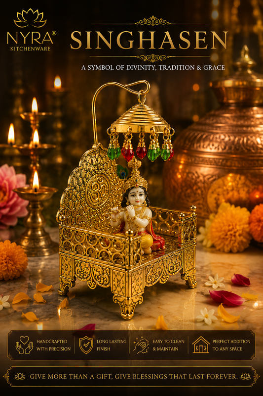 Nyra Kitchenware Singhasen brass baby cradle ornament featuring a small Lord Krishna figurine, displayed in a warm, festive setting with brass lamps and marigold flowers.