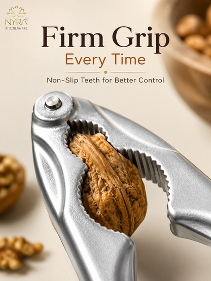A silver metal nutcracker with a walnut in the center, shown with promotional text reading 'Firm Grip Every Time' and 'Non-Slip Teeth for Better Control.' The NYRA Kitchenware logo appears in the top left, and blurred walnuts and a bowl are visible in the background.