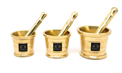 Three small metallic gold mortar and pestle sets arranged side by side on a white background, each with a black square logo plaque on the front.
