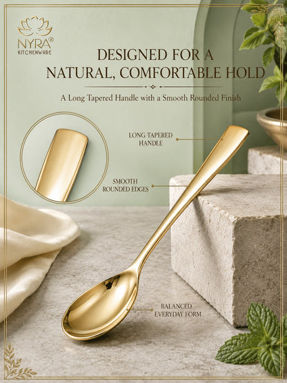 A gold-colored kitchen spoon displayed on a stone block with a sage green background and product feature callouts. The image includes text reading 'DESIGNED FOR A NATURAL, COMFORTABLE HOLD' and 'A Long Tapered Handle with a Smooth Rounded Finish,' along with a circular inset showing the handle shape.