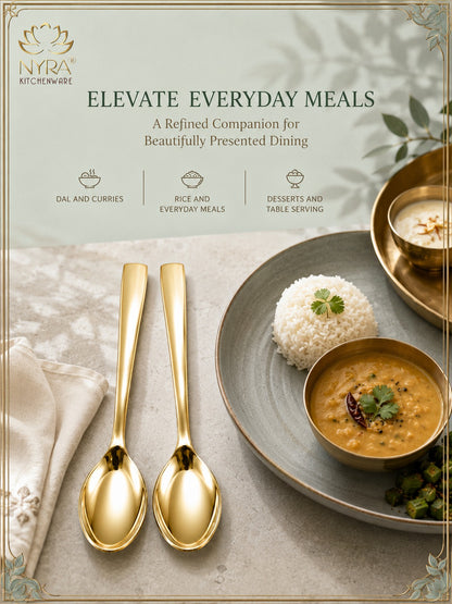 Gold-toned dinnerware set from NyrA Kitchenware, featuring two elegant spoons and a matching bowl, styled on a plate with rice and curry in a beautifully presented dining setting.