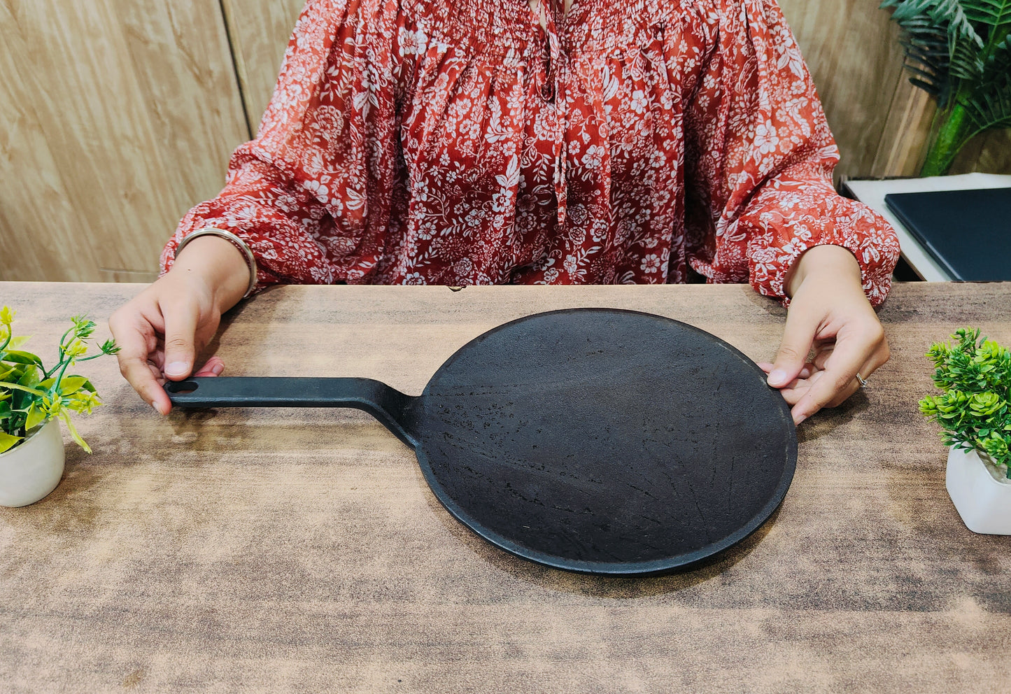 showing in hand Pre-Seasoned Cast Iron Roti/Chapatti Tawa with Handle