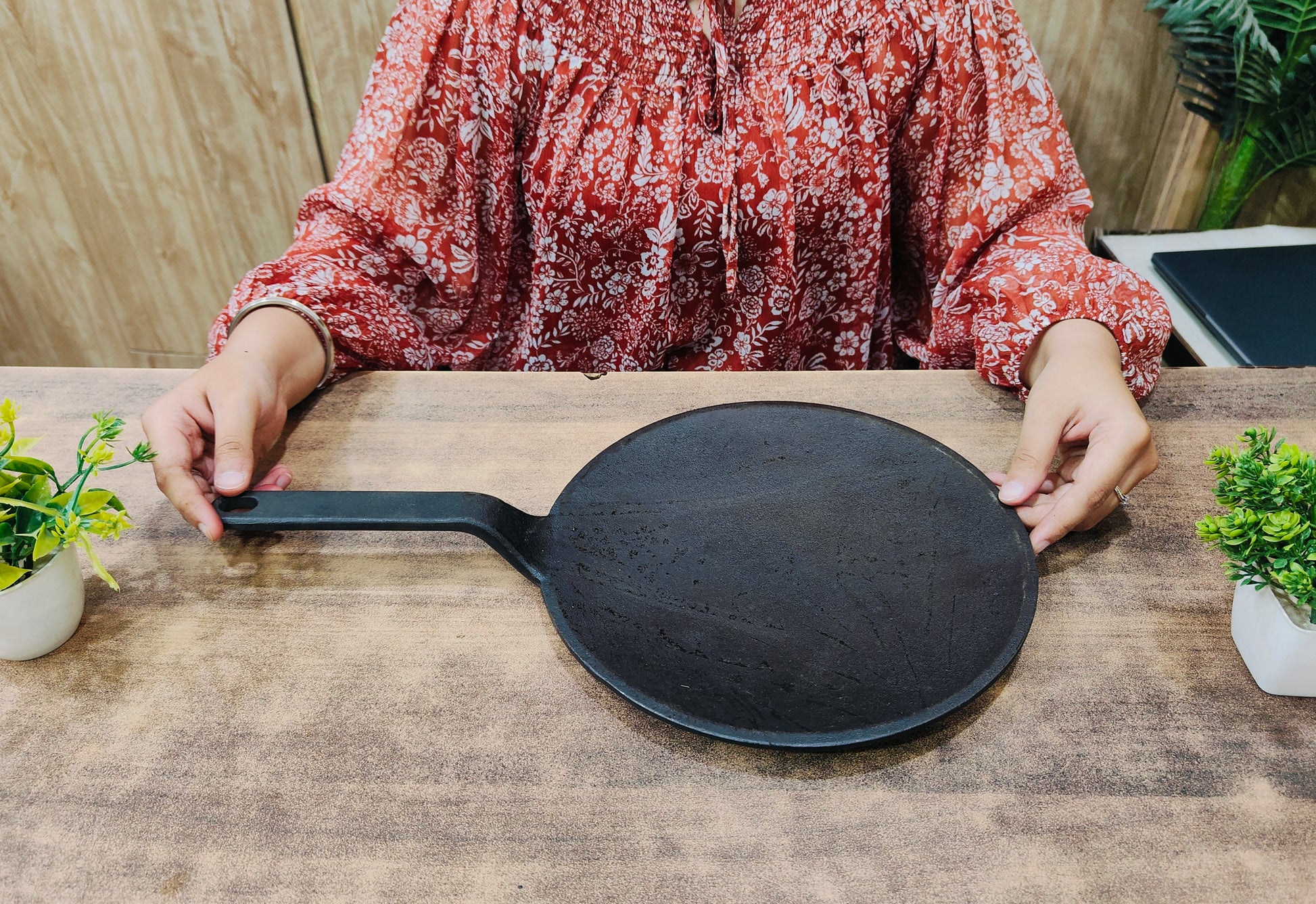 showing in hand Pre-Seasoned Cast Iron Roti/Chapatti Tawa with Handle