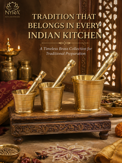 Three brass kitchen tools, including two pestles and one mortar, displayed on a carved wooden stand in a traditional Indian kitchen setting. The image features the NYRA Kitchenware logo in the top left corner and the text 'TRADITION THAT BELONGS IN EVERY INDIAN KITCHEN' at the top.