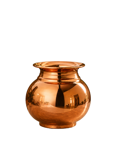 A shiny copper-colored metal pot with a rounded body, flared rim, and short base, photographed on a plain white background.