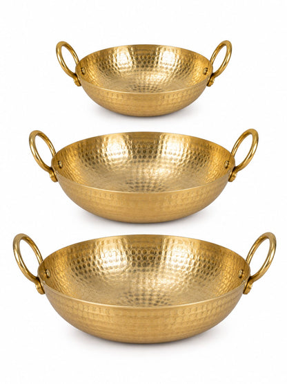 Three hammered brass kadhai pans of different sizes, arranged vertically on a clean white background.