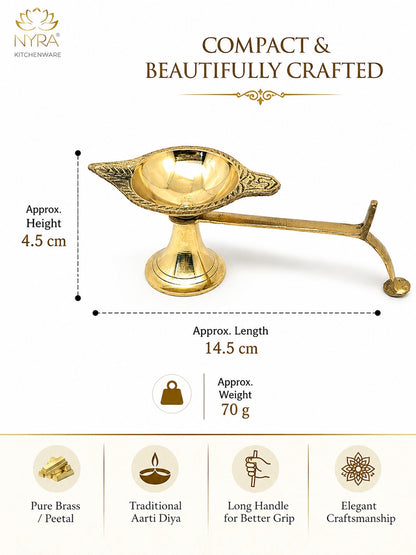 A brass oil lamp (diya) shown on a white background with product dimensions, weight, and feature icons. The image includes the NYRA Kitchenware logo and text reading 'Compact & Beautifully Crafted,' 'Approx.