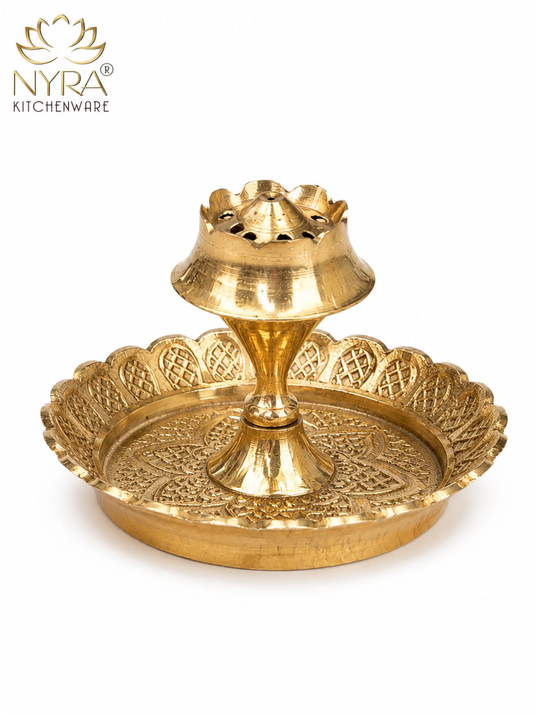 A brass double-tiered diya holder with an ornate scalloped tray and central stand, shown on a white background with the NYRA Kitchenware logo in the top left corner.