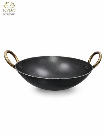 A black cast iron kadhai with brass-colored loop handles, shown on a plain white background with the NYRA Kitchenware logo in the top left corner.