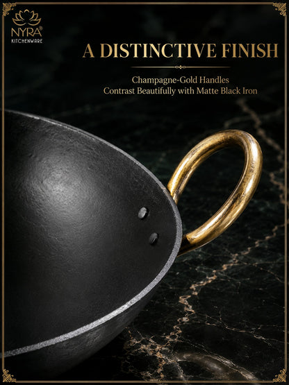 Close-up of a black iron wok with a champagne-gold handle on a dark marble surface, with promotional text reading 'A DISTINCTIVE FINISH' and 'Champagne-Gold Handles Contrast Beautifully with Matte Black Iron.' NYRA Kitchenware logo is visible in the top left.