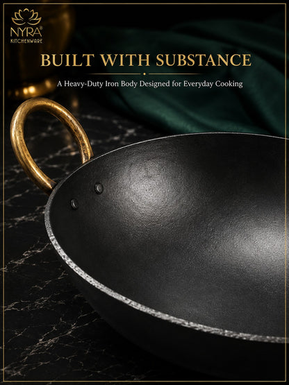 A heavy-duty black iron kadhai wok with a gold-colored handle, shown on a dark marble surface with a green cloth in the background. The image features promotional text at the top reading 'BUILT WITH SUBSTANCE' and shows the NYRA KITCHENWARE brand logo.