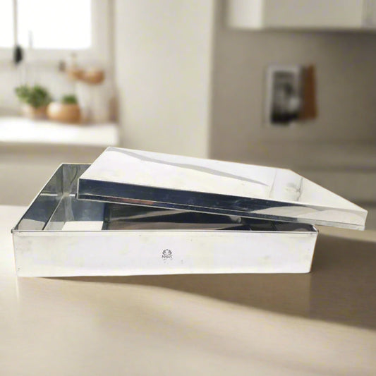 A stainless steel storage container with a lid resting on top, placed on a kitchen countertop.